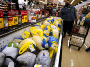 People shop for frozen turkeys for Thanksgiving dinner at a grocery store in 2021. (AP Photo/Nam Y.
