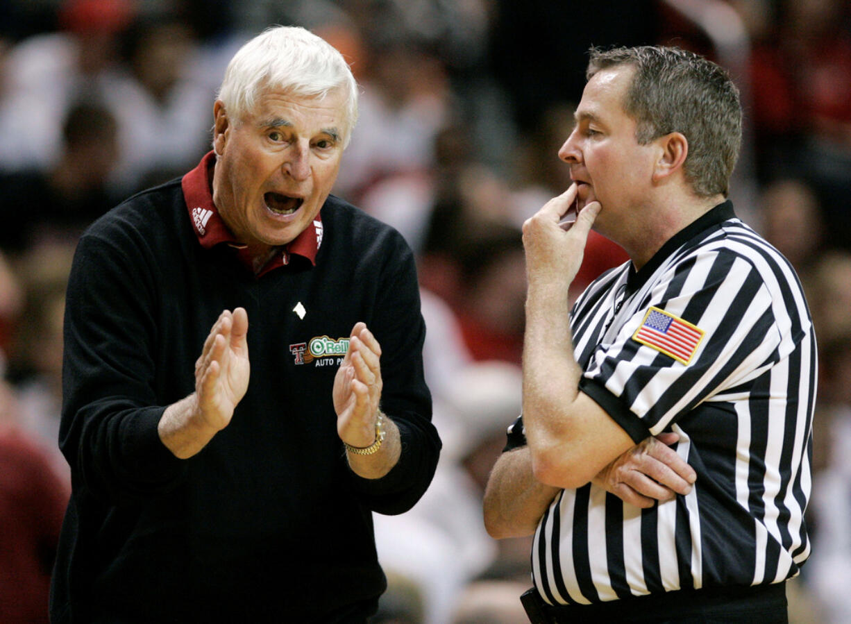 FILE - Texas Tech coach Bob Knight, left, argues a call with an NCAA official during a basketball game against Texas A&amp;M in Lubbock, Texas, Wednesday, Jan. 16, 2008. Knight earned his 900th career win in the 68-53 win over Texas A&amp;M. Bob Knight, the brilliant and combustible coach who won three NCAA titles at Indiana and for years was the scowling face of college basketball has died. He was 83. Knight's family made the announcement on social media Wednesday evening, Nov. 1, 2023.