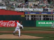FILE - Oakland Athletics' Paul Blackburn pitches against the San Francisco Giants below signs hanging in right field protesting the team's potential move to Las Vegas and to call for managment to sell the team during the first inning of a baseball game in Oakland, Calif., Saturday, Aug. 5, 2023. Major League Baseball team owners are set to vote Thursday, Nov.