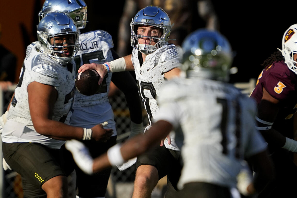 Oregon quarterback Bo Nix, center, looks to pass against Arizona State during the first half on an NCAA college football game, Saturday, Nov. 18, 2023, in Tempe, Ariz.