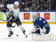 Seattle Kraken's Brandon Tanev (13) tries to tap in a shot against Vancouver Canucks goaltender Thatcher Demko (35) during the first period of an NHL hockey game Saturday, Nov. 18, 2023, in Vancouver, British Columbia.