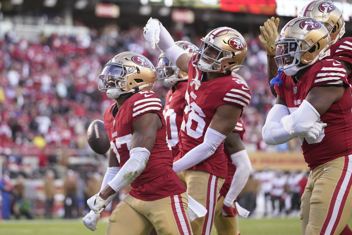 San Francisco 49ers safety Ji'Ayir Brown, left, celebrates with teammates after intercepting a pass from Tampa Bay Buccaneers quarterback Baker Mayfield during the second half of an NFL football game in Santa Clara, Calif., Sunday, Nov. 19, 2023. (AP Photo/Godofredo A.