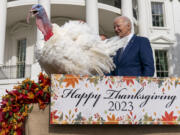 President Joe Biden stands next to Liberty, one of the two national Thanksgiving turkeys, after pardoning them during a ceremony on the South Lawn of the White House in Washington, Monday, Nov. 20, 2023.