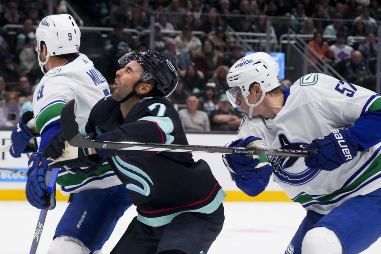 Vancouver Canucks defenseman Tyler Myers, right, high-sticks Seattle Kraken right wing Jordan Eberle during the first period of an NHL hockey game Friday, Nov. 24, 2023, in Seattle.