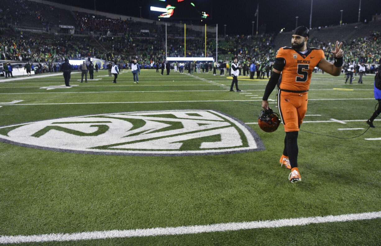 Oregon State quarterback DJ Uiagalelei (5) walks by the Pac-12 logo and waves to fans after the team's game against Oregon on Friday, Nov. 24, 2023, in Eugene, Ore. This was the final Pac-12 football game for the team.