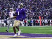 Washington wide receiver Rome Odunze (1) runs in a touchdown in front of Washington State defensive back Sam Lockett III (0) during the first half of an NCAA college football game ,Saturday, Nov. 25, 2023, in Seattle.