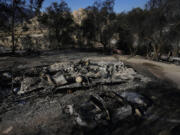 Burned vehicles and a mobile home are left charred by the Highland Fire on Luis Quinonez' property, Tuesday, Oct. 31, 2023, in Aguanga, Calif.