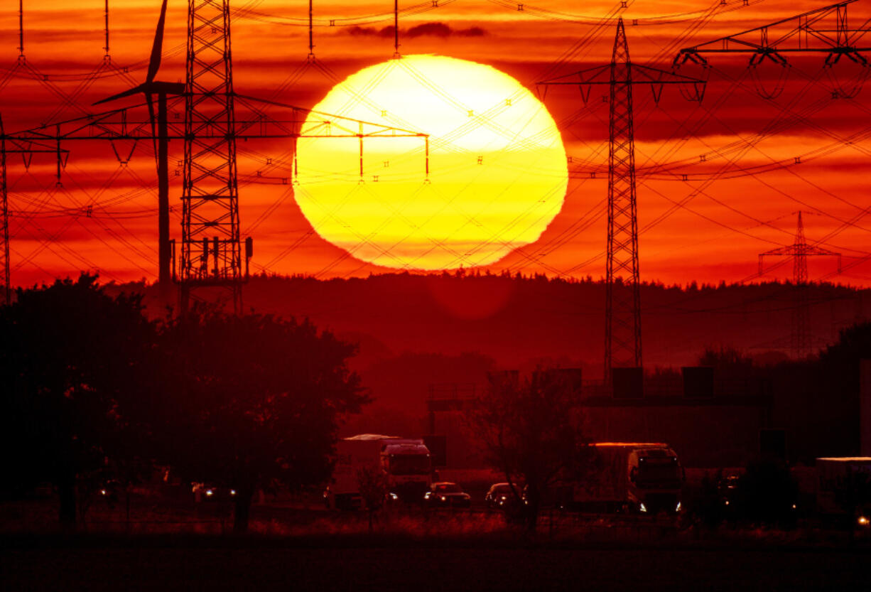 FILE - The sun rises above a highway in Frankfurt, Germany, Aug. 2, 2022. Former NASA top scientist James Hansen is warning that global warming is accelerating faster than most models are showing, a contention that other scientists think is overblown. He argues that since 2010 there is more sun energy in the atmosphere, and less of the particles that can reflect it back into space thanks to efforts to cut pollution.