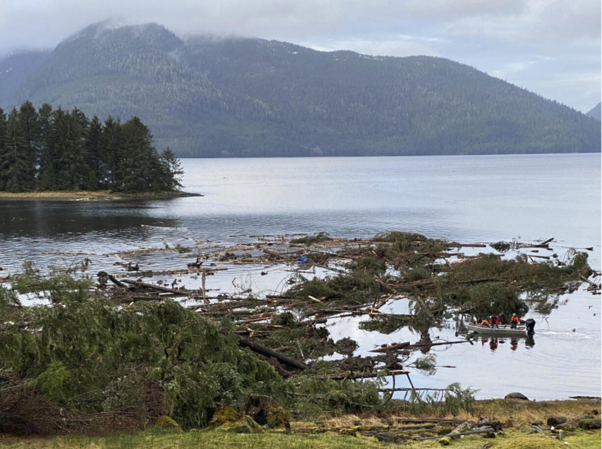 This photo provided by the Alaska Department of Public Safety shows boat operators patrolling the waters near a massive landslide that extends into the sea at mile 11 of the Zimovia Highway, Wednesday, Nov. 22, 2023, in Wrangell, Alaska. Search and rescue operations have been ongoing since the incident was reported Nov. 20, 2023. Three people have died and searchers looked Wednesday, Nov. 22, 2023, for three others who remain missing after a landslide ripped through a remote Alaska fishing community on Monday, Nov. 20, 2023.