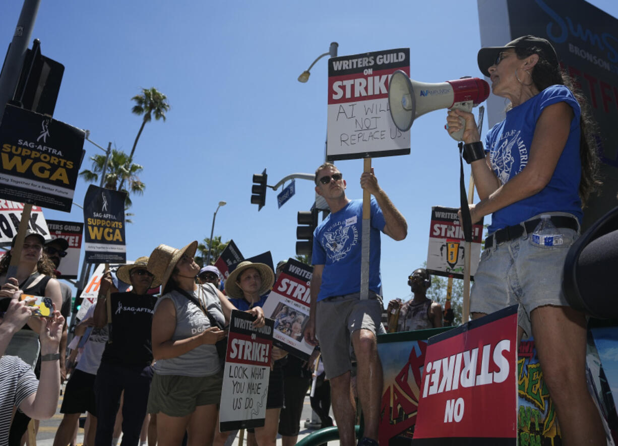 File - Actor and filmmaker Justine Bateman, right, speaks outside Netflix during a Writers Guild rally on July 13, 2023, in Los Angeles. Bateman said she was disturbed that AI models were &quot;ingesting 100 years of film&quot; and TV in a way that could destroy the structure of the film business and replace large portions of its labor pipeline. (AP Photo/Mark J.