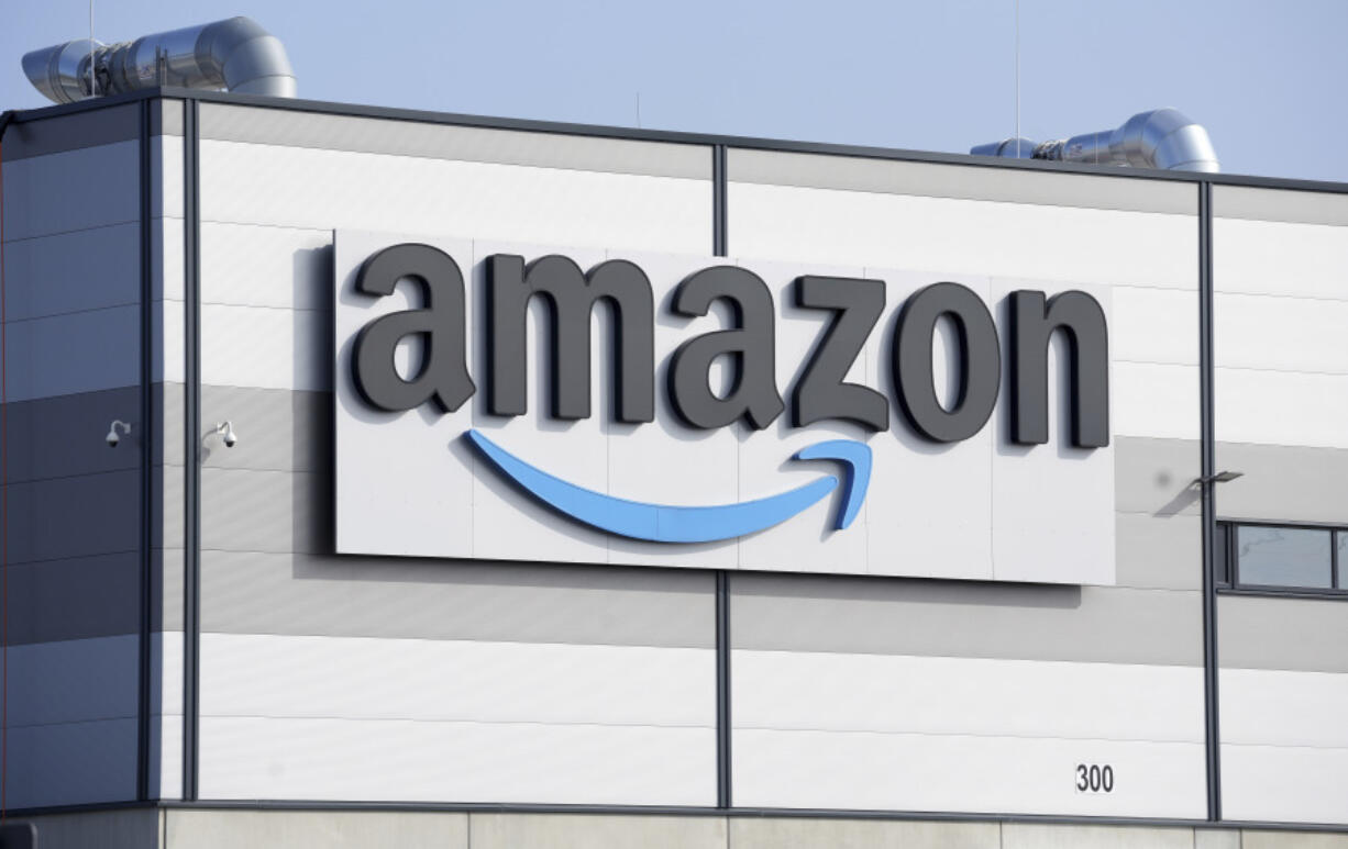 FILE - An Amazon company logo is seen on the facade of a company's building in Schoenefeld near Berlin, Germany, on March 18, 2022. Amazon and Meta settled separate U.K. antitrust investigations by agreeing to stop practices that give them an unfair advantage over merchants and customers using their platforms, the watchdog said Friday.