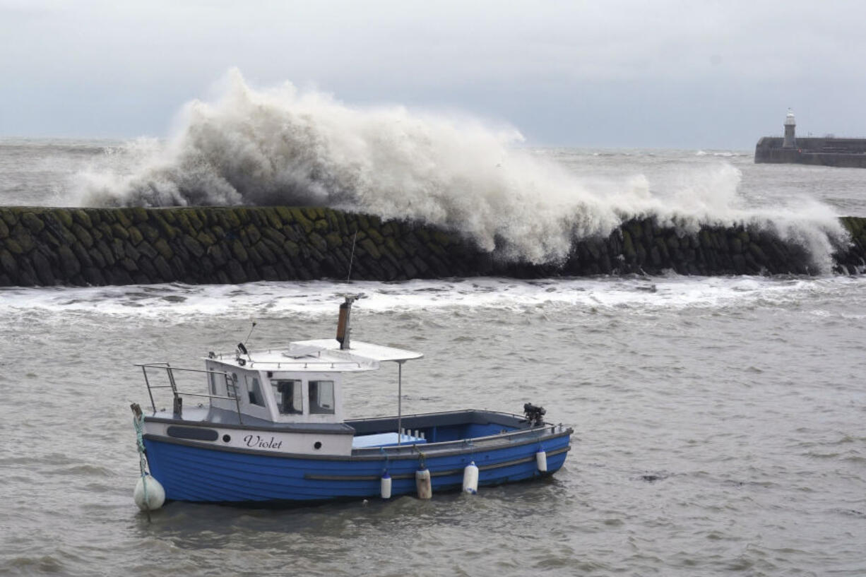 Waves crash behind a fishing boat at Folkestone harbour, England, Thursday, Nov, 2, 2023, as Storm Ciaran brings high winds and heavy rain along the south coast of England.