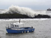 Waves crash behind a fishing boat at Folkestone harbour, England, Thursday, Nov, 2, 2023, as Storm Ciaran brings high winds and heavy rain along the south coast of England.