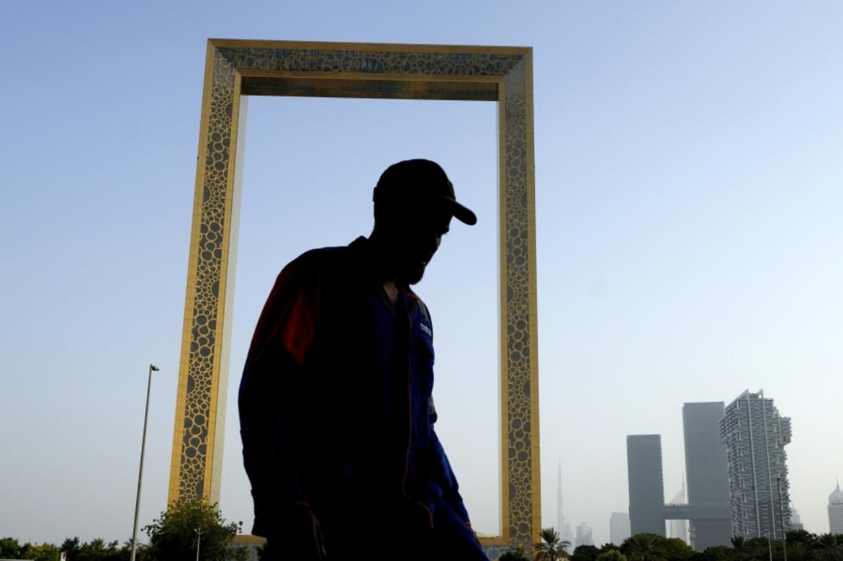 FILE - A man passes in front of the Dubai Frame in Dubai, United Arab Emirates, June 29, 2023. Dubai hosts the United Nations COP28 climate talks starting Nov. 30.