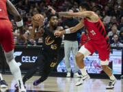 Cleveland Cavaliers guard Donovan Mitchell, left, drives to the basket as Portland Trail Blazers forward Toumani Camara defends during the first half of an NBA basketball game in Portland, Ore., Wednesday, Nov. 15, 2023.