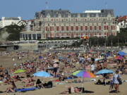 FILE - People sunbathe on Biarritz&rsquo; beach, southwestern France, Oct. 7, 2023. October was the fifth straight month that Earth set a record for the hottest month in recorded history.