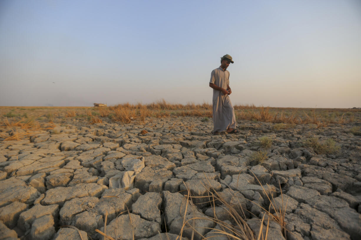 FIEL - A fisherman walks across a dry patch of land in the marshes in Dhi Qar province, Iraq, Sept. 2, 2022. The three-year drought that has left millions of people in Syria, Iraq and Iran with little water wouldn&rsquo;t have happened without human-caused climate change, according to a new study on Wednesday, Nov. 8, 2023.