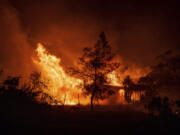 FILE - A structure is engulfed in flames as a wildfire called the Highland Fire burns in Aguanga, Calif., Oct. 30, 2023. Revved-up climate change now permeates Americans&rsquo; daily lives with harm that is &ldquo;already far-reaching and worsening across every region of the United States,&rdquo; a massive new government report says Tuesday, Nov. 14.