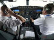 File - Pilots conduct a pre-flight check in the cockpit of a jet before taking off from Dallas Fort Worth airport in Grapevine, Texas, on Dec. 2, 2020. Aviation experts say the incident on Sunday in which an off-duty pilot, riding in a jump seat in a cockpit, tried to disable a jetliner in midflight renews questions about the threat posed by airline workers who have special access to places where passengers can't go.