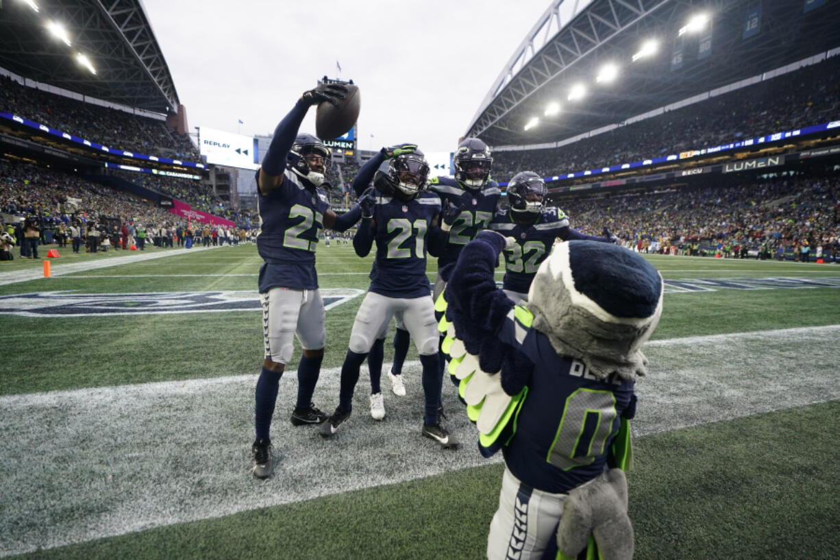 Seattle Seahawks cornerback Riq Woolen center, celebrates with teammates after a fumble recovery in the second half of an NFL football game against the Washington Commanders in Seattle, Sunday, Nov. 12, 2023.