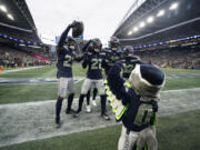 Seattle Seahawks cornerback Riq Woolen center, celebrates with teammates after a fumble recovery in the second half of an NFL football game against the Washington Commanders in Seattle, Sunday, Nov. 12, 2023.