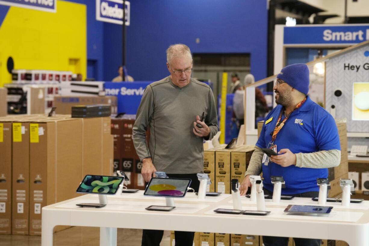 A customer and sales associate chat about mobile devices at a Best Buy store Tuesday, Nov. 21, 2023, in southeast Denver. On Thursday, the Commerce Department issues its October report on consumer spending.