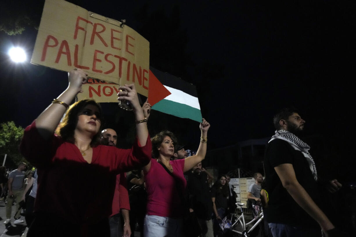 Pro Palestinian protesters hold placards and Palestinians flags as they march in support of Palestinians in the capital Nicosia, Cyprus, on Tuesday, Oct. 31, 2023.