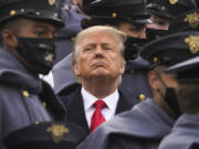 FIlE - Surrounded by Army cadets, President Donald Trump watches the first half of the 121st Army-Navy Football Game in Michie Stadium at the United States Military Academy, Saturday, Dec. 12, 2020, in West Point, N.Y. Experts in constitutional law and the military say the Insurrection Act gives presidents tremendous power with few restraints. Recent statements by former President Donald Trump raise questions about how he might use it if he wins another term.