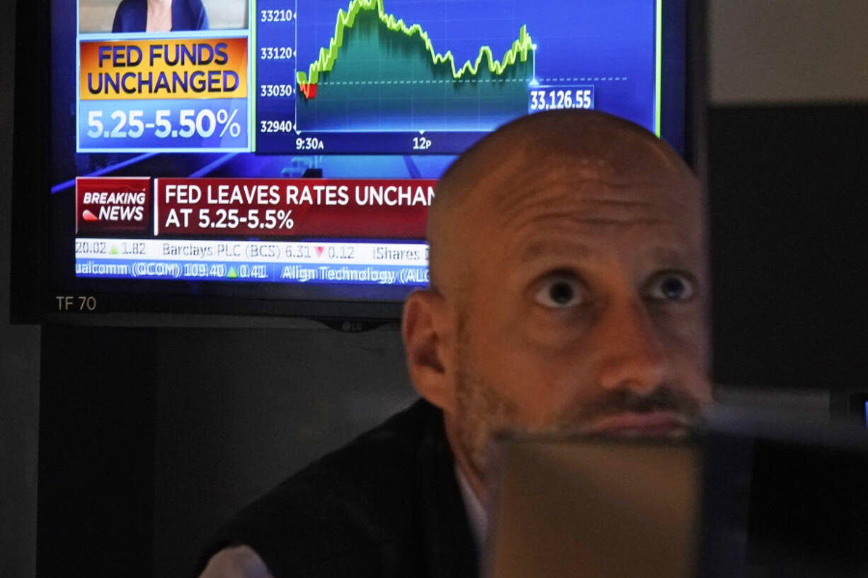 A television screen shows the rate decision of the Federal Reserve as Specialist Meric Greenbaum works at his post on the floor of the New York Stock Exchange, Wednesday, Nov. 1, 2023.