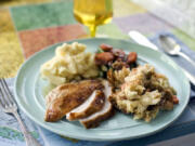 A plate of roasted turkey and gravy, stuffing, mashed potatoes and glazed carrots.