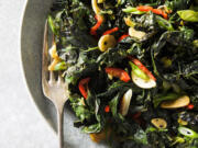 This image released by Milk Street shows a recipe for charred kale with garlic, chilies and lime.