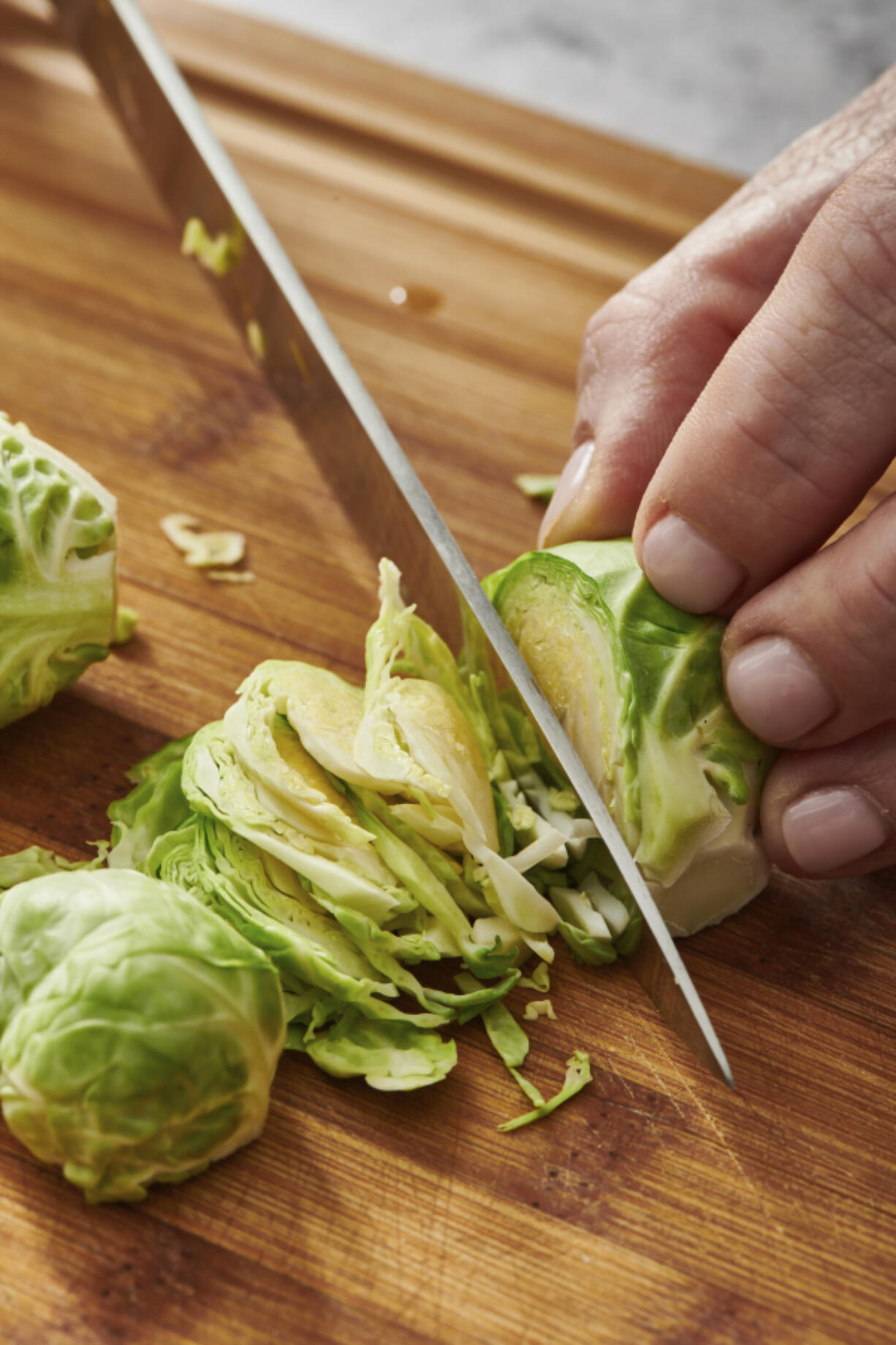 This image provided by Cheyenne Cohen shows Brussel sprouts being sliced on a chopping board. Brussels sprouts are often cooked as a side dish, especially during the cold weather months. They are particularly popular as part of holiday meals such as Thanksgiving and Christmas. And if you think you don&rsquo;t like Brussels sprouts, I&rsquo;m here to say AP food writer Katie Workman says you just haven&rsquo;t had them prepared well.