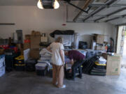 Lonnie Phillips, right, and his wife, Sandy, sift through their belongings stored at a friend's garage in Lone Tree, Colo., Monday, Sept. 4, 2023. Since Sandy's daughter, Jessica Ghawi, was killed in a 2012 mass shooting in a movie theater, the pace of other mass killings only intensified. Instead of tighter gun laws, some states loosened them. Exhausted, disgusted and impoverished, the Phillipses recently moved to Mexico.