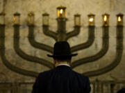 An Ultra-Orthodox Jewish man stands in front of a menorah on the third eve of Hanukkah, at the Western Wall, Judaism&rsquo;s holiest site in Jerusalem&rsquo;s old city, in 2009.