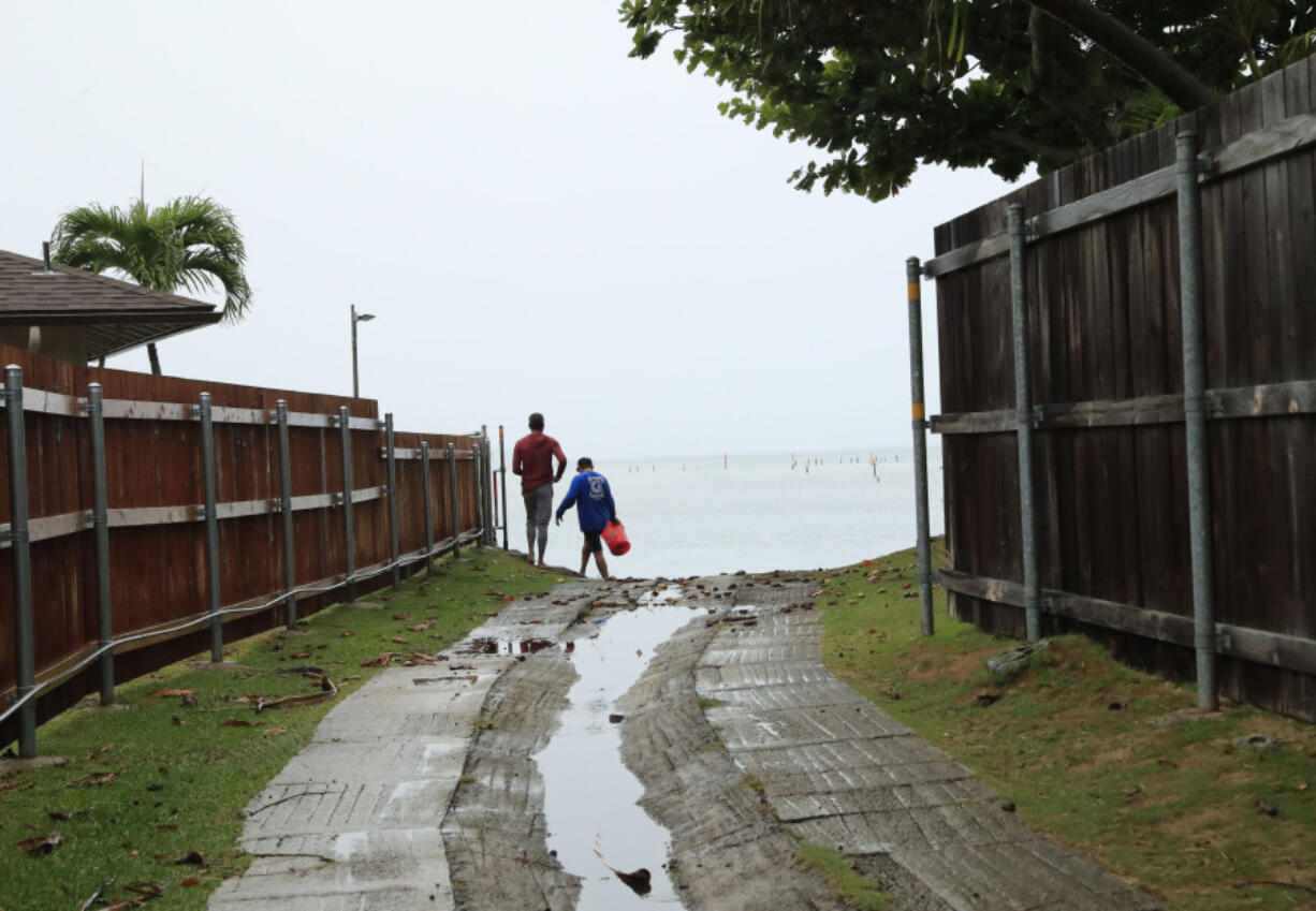 Residents look at a downed U.S. Navy aircraft in Kaneohe Bay, Monday, Nov. 20, 2023, in Kaneohe, Hawaii.