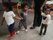 A toddler teacher walks toddlers to a classroom at the Life Learning Center - Head Start, in Cincinnati, Tuesday, Nov. 21, 2023. A new plan from the Biden administration could significantly increase salaries for hundreds of low-paid early childhood teachers caring for the country&rsquo;s poorest children but might also force some centers to cut enrollment.