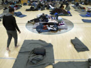 FILE - Migrants rest at a makeshift shelter in Denver, Jan. 6, 2023.  Five mayors from around the U.S. want a meeting with President Joe Biden to ask for help controlling the continued arrival of large groups of migrants to their cities. The mayors of Denver, Chicago, Houston, New York and Los Angeles say in a letter to Biden that there has been little to no coordination, support or resources and that is leading to a crisis.