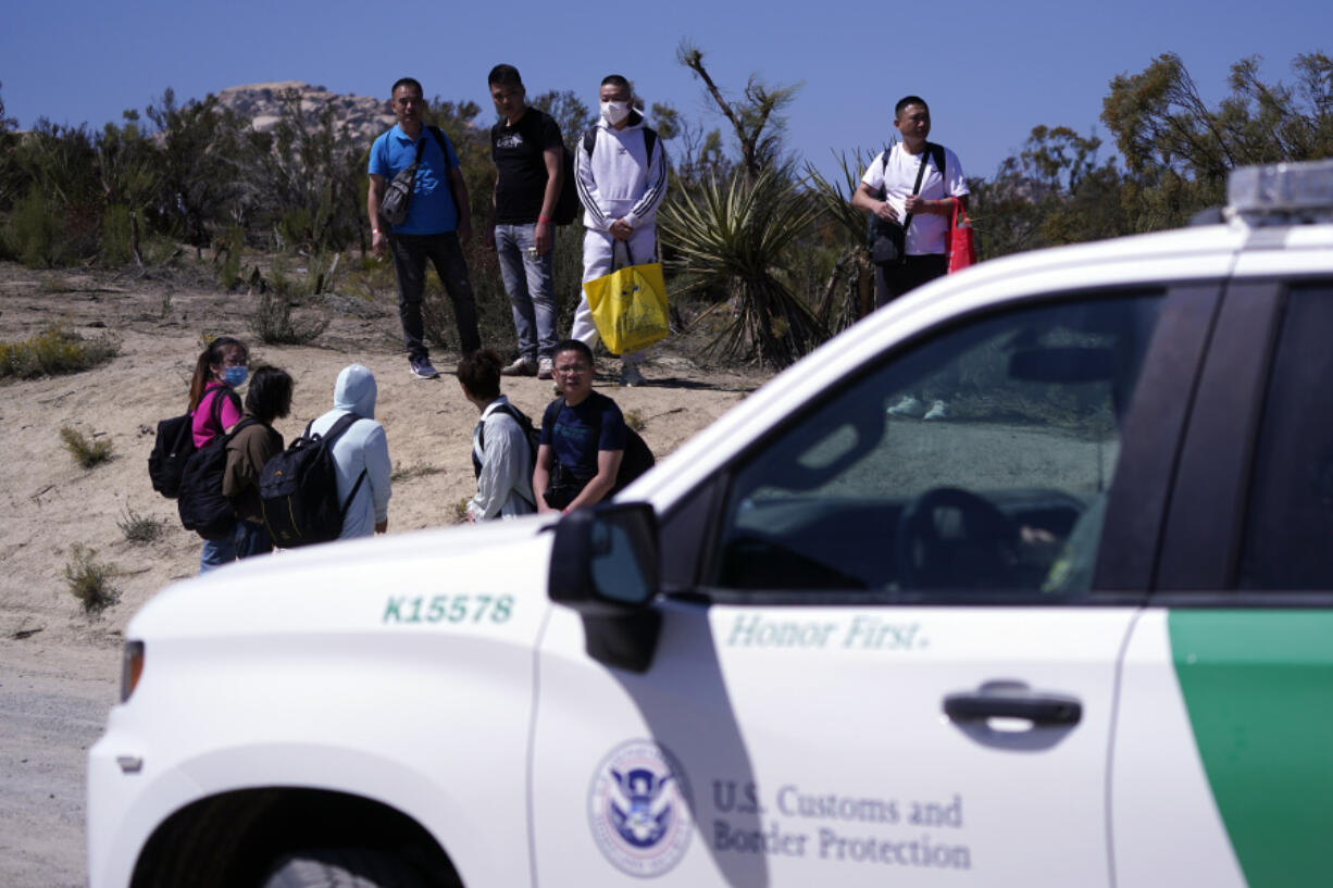 FILE - Asylum-seekers wait in a makeshift camp after crossing the nearby border with Mexico, Sept. 20, 2023, near Jacumba Hot Springs, Calif.  U.S. authorities say illegal border crossings from Mexico fell 14% in October from a month earlier, following three months of big increases. The decline comes during the resumption of deportation flights to Venezuela, shortly after Venezuelans replaced Mexicans as the largest nationality appearing at the border.