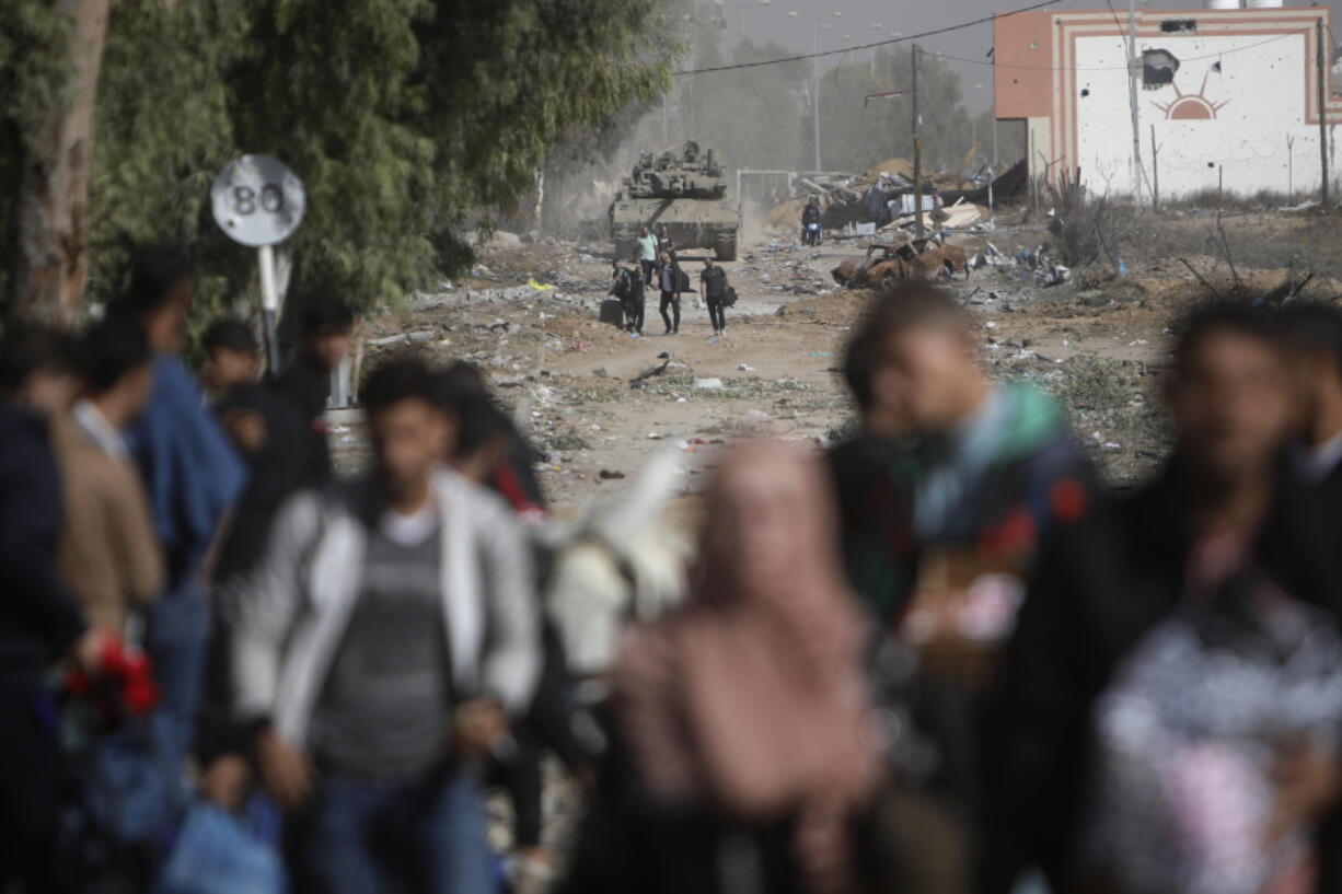 Palestinians flee to northern Gaza as Israeli tanks block the Salah al-Din road in the central Gaza Strip on Friday, Nov. 24, 2023, as the four-day cease-fire in the Israel-Hamas war begins as part of an agreement that Qatar helped broker.