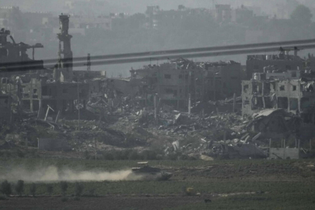 Israeli armed vehicles drive along the outskirts of Gaza City, as seen from southern Israel, Thursday Nov. 9, 2023.