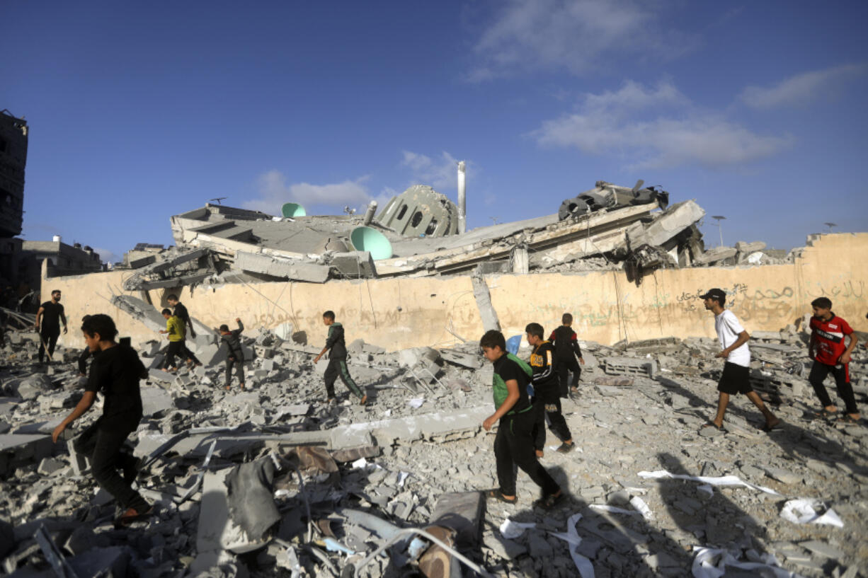 FILE - Palestinians inspect the damage of a destroyed mosque following an Israeli airstrike in Khan Younis refugee camp, southern Gaza Strip on Nov. 8, 2023. Entire generations of Palestinian families in the besieged Gaza Strip have been killed in airstrikes in the ongoing Hamas-Israel war. They include infants to elderly grandparents, killed in attacks the Israeli army says aim to root out the militant group from the densely populated coastal territory.