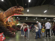 Children wait in line with their families for a chance to ride dinosaurs at Jurassic Quest at the Clark County Events Center in November 2022.