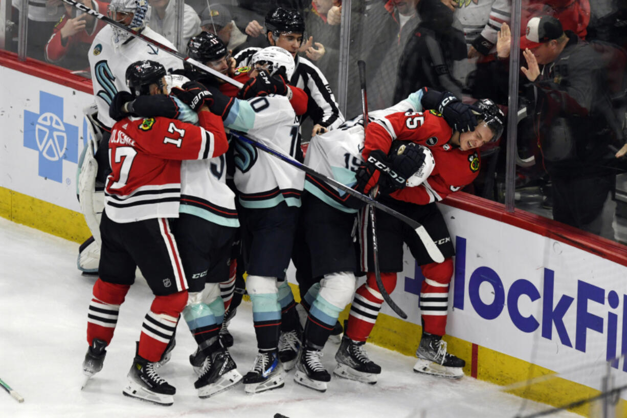 Players from the Chicago Blackhawks and Seattle Kraken fight during the second period of an NHL hockey game, Tuesday, Nov. 28, 2023, in Chicago.