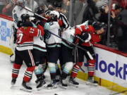 Players from the Chicago Blackhawks and Seattle Kraken fight during the second period of an NHL hockey game, Tuesday, Nov. 28, 2023, in Chicago.