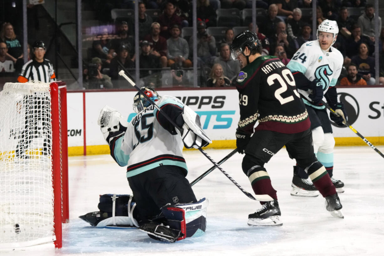 Seattle Kraken goaltender Joey Daccord, left, gives up a goal to Arizona Coyotes&rsquo; Clayton Keller as Coyotes center Barrett Hayton (29) and Kraken defenseman Jamie Oleksiak (24) look on during the third period of an NHL hockey game Tuesday, Nov. 7, 2023, in Tempe, Ariz. The Coyotes won 4-3 in a shootout. (AP Photo/Ross D.