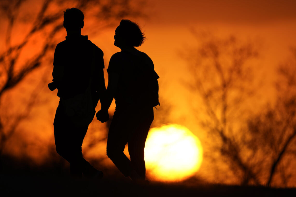 FILE - A couple walks through a park at sunset, March 10, 2021, in Kansas City, Mo. U.S. life expectancy rose in 2022 &mdash; by more than a year &mdash; after plunging two straight years at the beginning of the COVID-19 pandemic, according to a new government report released Wednesday, Nov. 29, 2023. The rise was mainly due to the waning of the pandemic in 2022, researchers said at the Centers for Disease Control and Prevention.