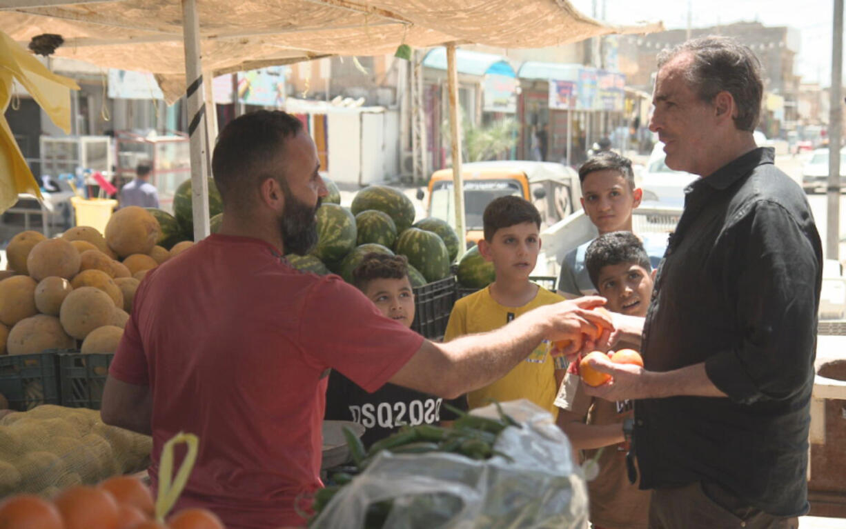 This image released by ABC News Studios shows Bob Woodruff, right, in the marketplace in Sabaa Al Bour, Iraq. Woodruff has returned to the Iraqi roadside where a bomb nearly killed him while on assignment for ABC News in 2006.  &ldquo;After the Blast: The Will to Survive,&rdquo; which airs on ABC Friday at 8 p.m. Eastern and begins streaming on Hulu a day later.