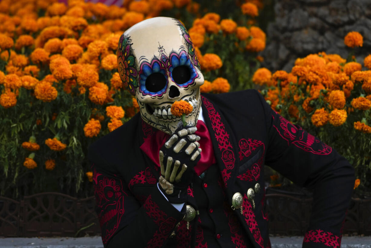 A Mexican mascot dressed as a catrin, a masculine version of the Day of the Dead Catrina, poses for photographers at the Hermanos Rodriguez race track in Mexico City, Thursday, Oct. 26, 2023. The track is hosting the Mexico City Grand Prix which begins Friday.