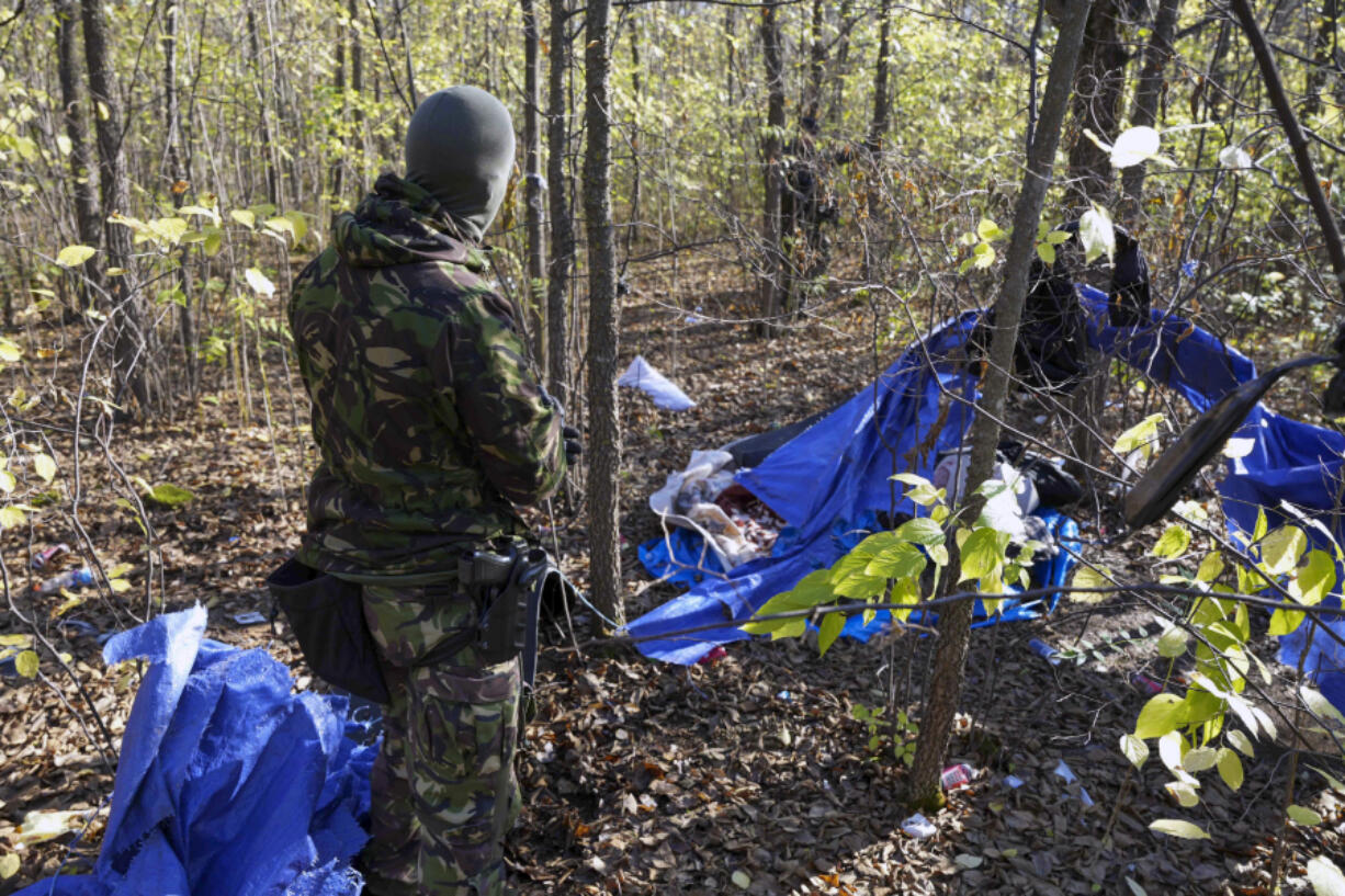 In this photo provided by the Serbian Interior Ministry, Serbian gendarmerie officers looking for migrants in a forest near the border between Serbia and Hungary, Serbia, Thursday, Nov. 2, 2023. Serbian police said Friday, Nov. 3, 2023 they made seven arrests on suspicion of smuggling people into Hungary as part of a days-long crackdown on irregular migration in the wake of a shooting last week in the border area that killed three migrants and wounded one. Reports of violence and gun battles have become common near the border between Serbia and Hungary, a European Union member state.