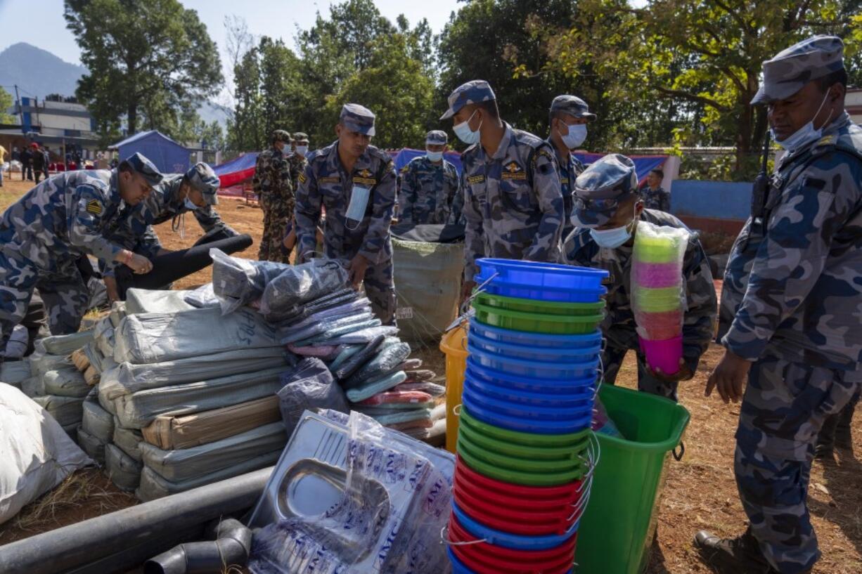Policemen pack relief material to distribute among earthquake survivors in Jajarkot District, northwestern Nepal, Monday, Nov. 6, 2023. The Friday night earthquake in the mountains of northwest Nepal killed more than 150 people and left thousands homeless.